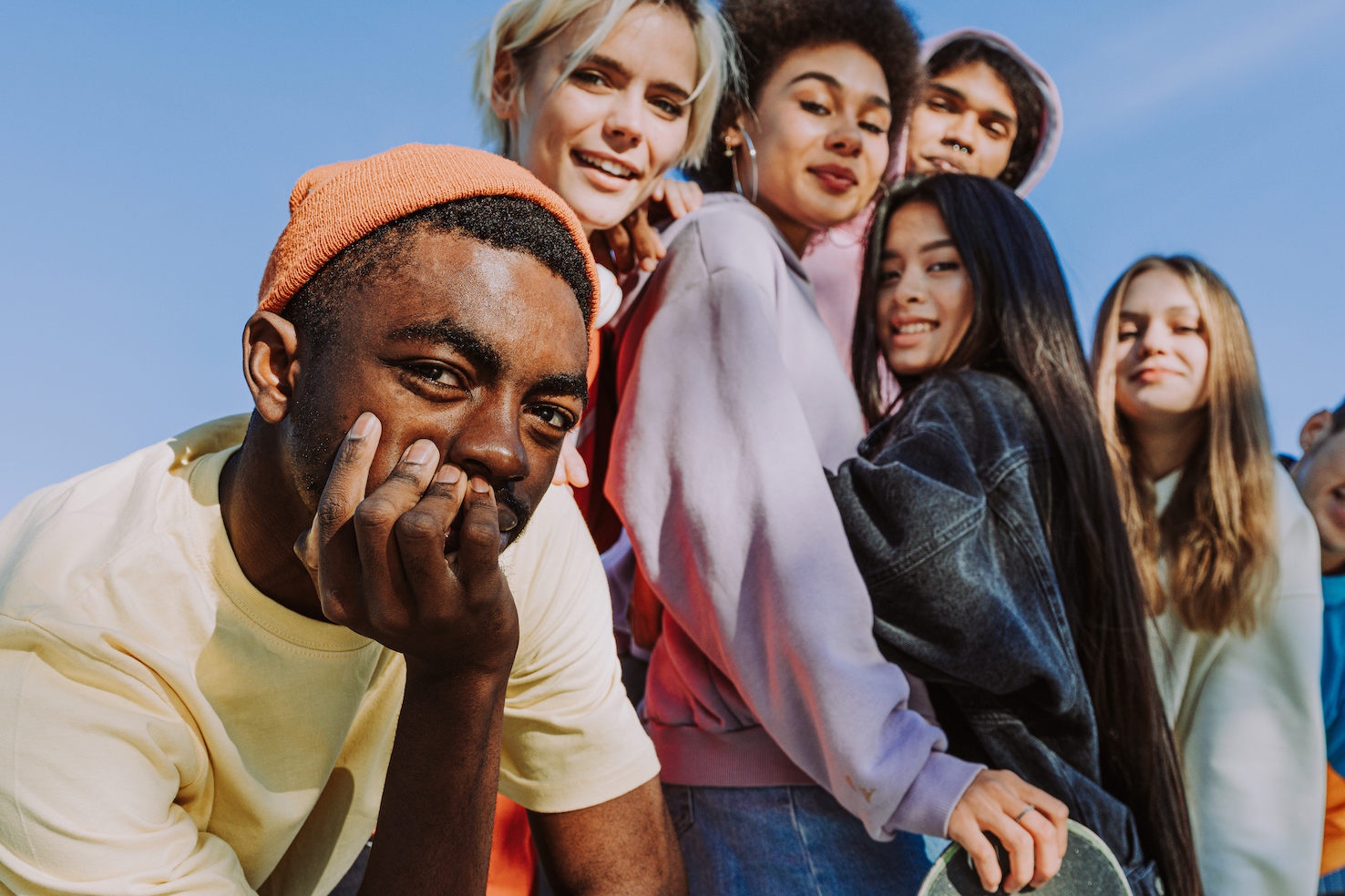 Multicultural group of young friends bonding outdoors and having fun 